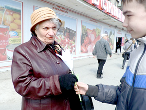 Участник акции Кирилл Зазерин (школа № 49) поздравляет одного из ветеранов города